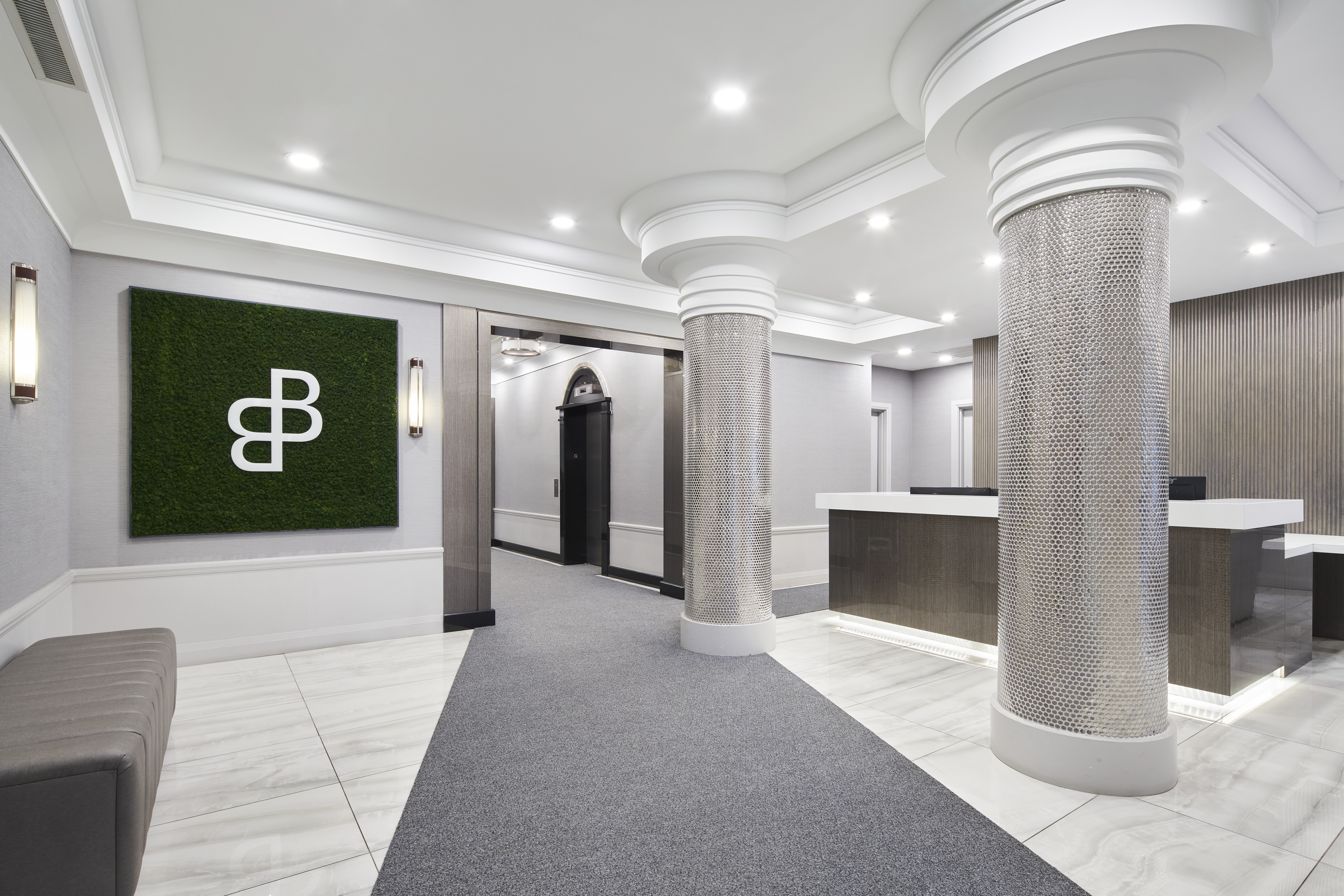 A reception area with a green sign with a white letter B on it.